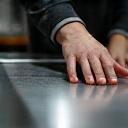 Mani che ispezionano la finitura di un tavolo in metallo